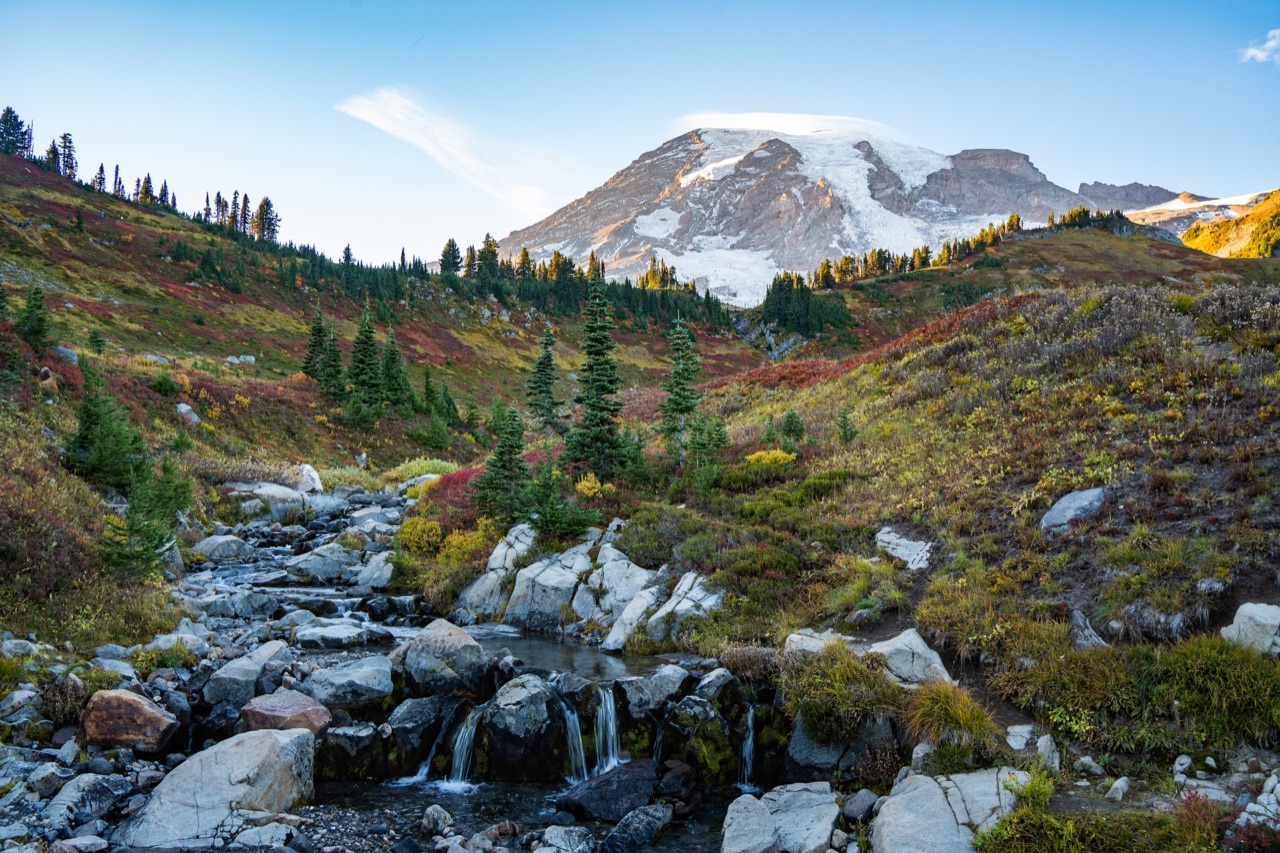 Mount Rainier above a waterfall, evergreens, and autumn meadows